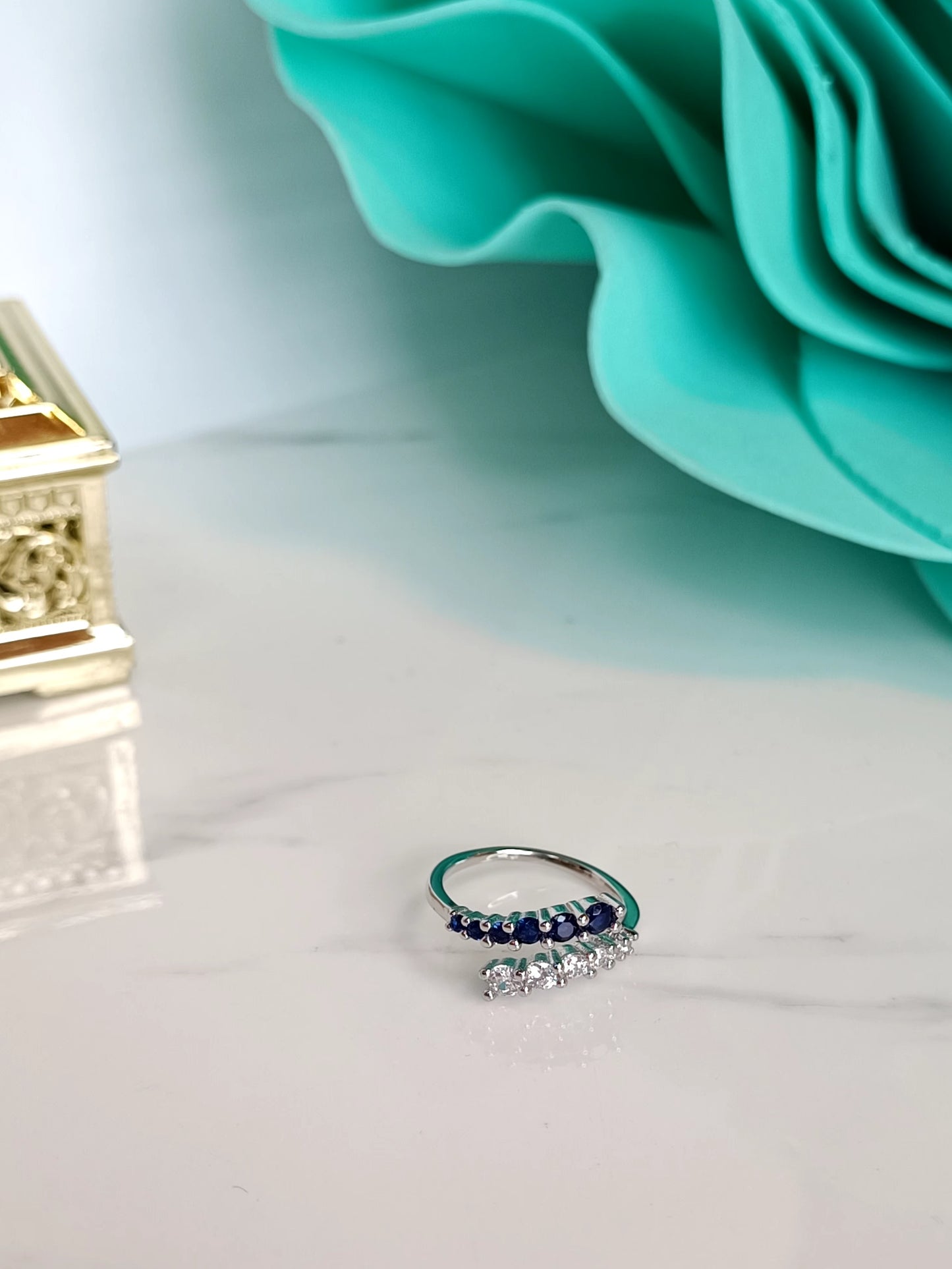 Anello Abbraccio in argento 925 e zirconi bianchi e zaffiro blu regolabile.